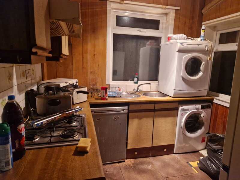Kitchen with appliances and clutter on the side